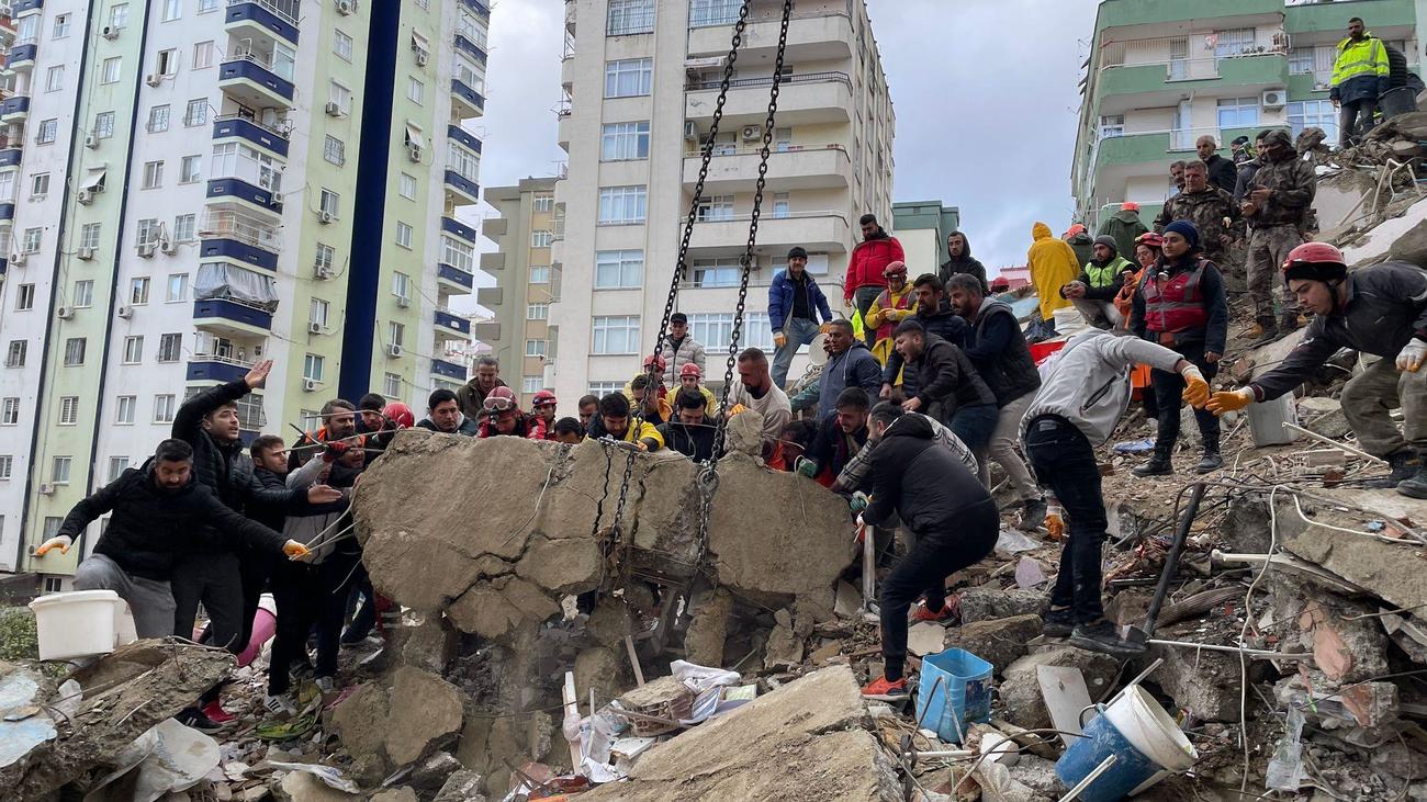 6日、トルコ南部アダナで救助活動する人たち（ゲッティ＝共同）