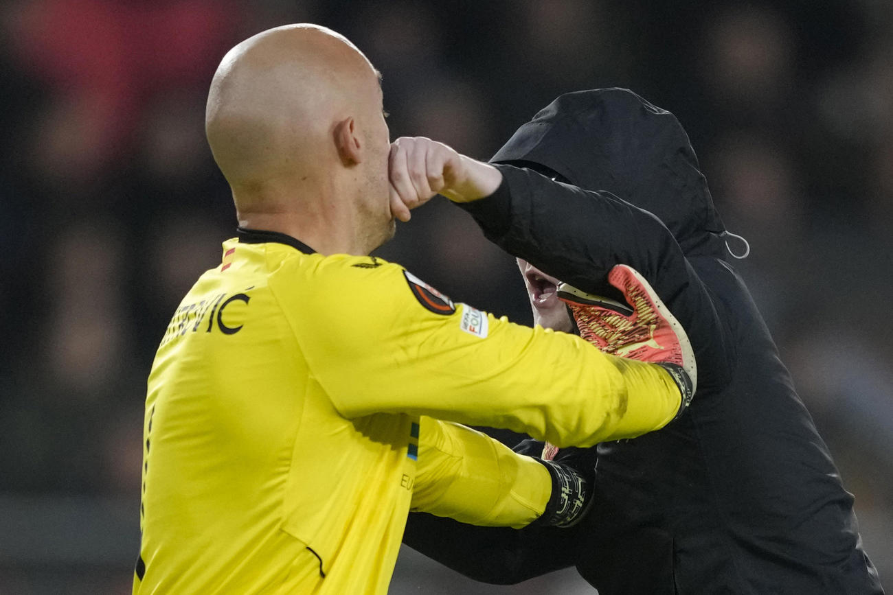 欧州リーグプレーオフ第2戦　乱入者のパンチを浴びるセビージャGKドミトロビッチ（左）（AP）