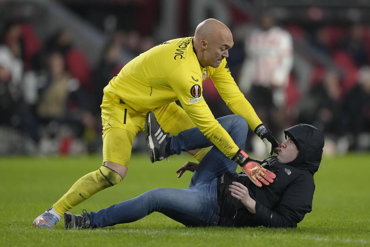 欧州リーグプレーオフ第2戦　乱入者と格闘するセビージャGKドミトロビッチ（上）（AP）