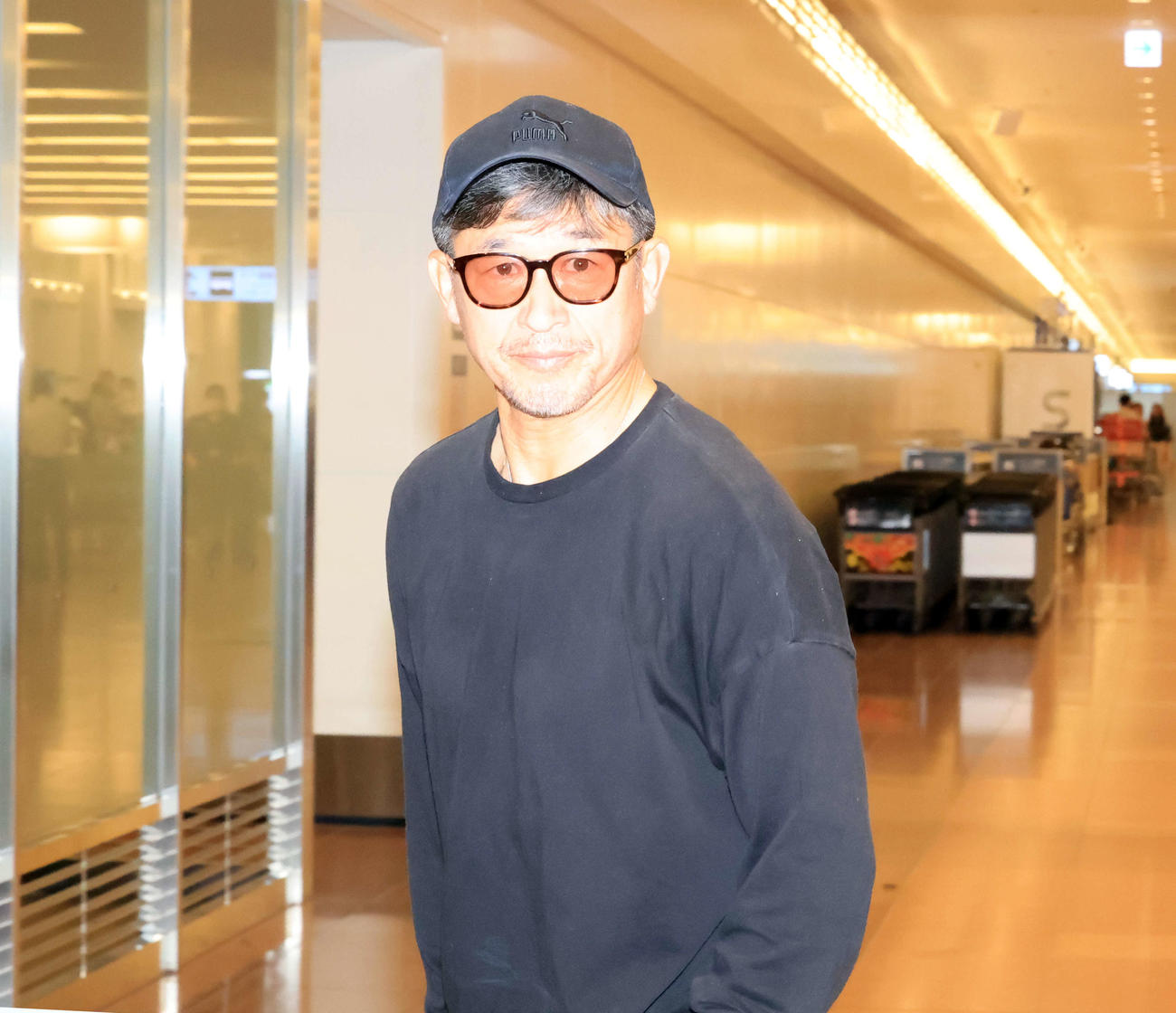 帰国したカズは報道陣が待つ待機所に向かう（撮影・浅見桂子）