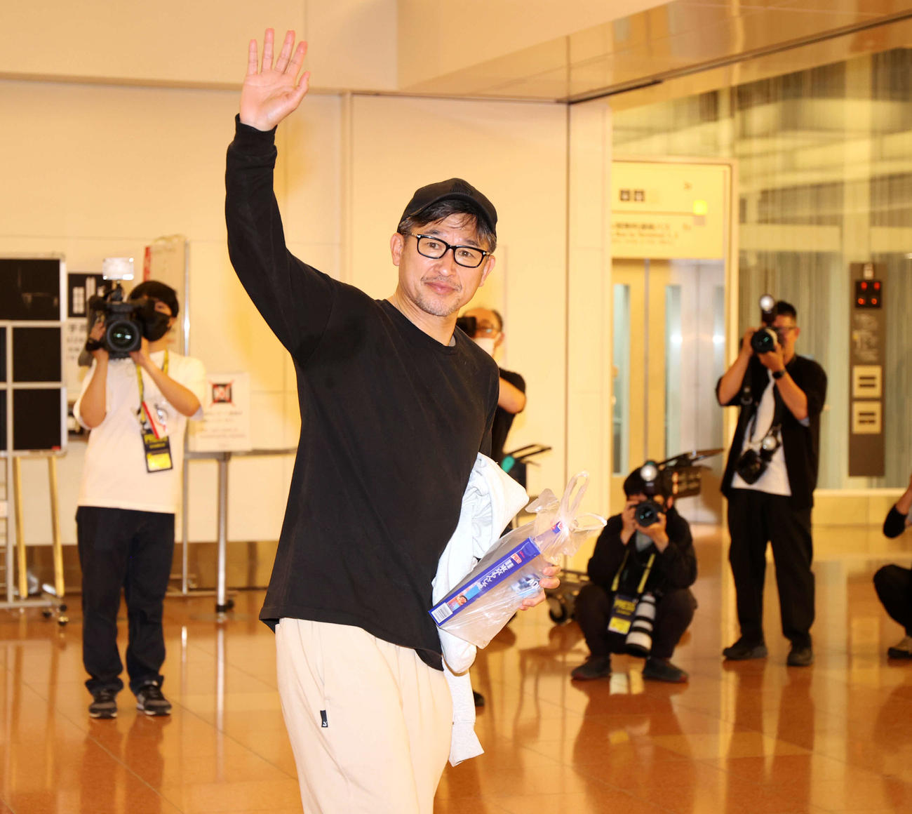帰国したカズは報道陣に手を振る（撮影・浅見桂子）