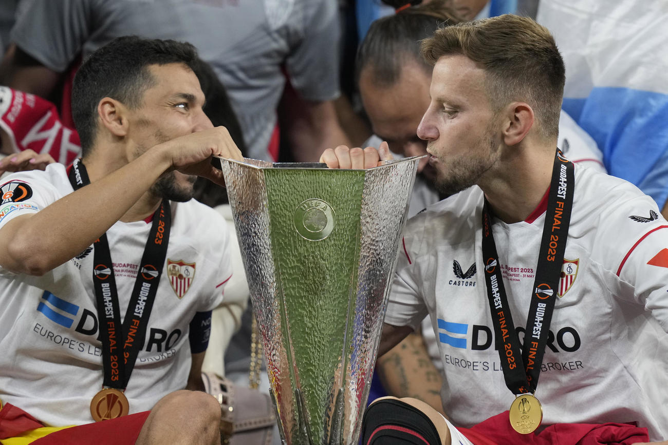 欧州リーグ優勝セレモニーでトロフィーにキスするセビリアのラキティッチ（右）（AP）