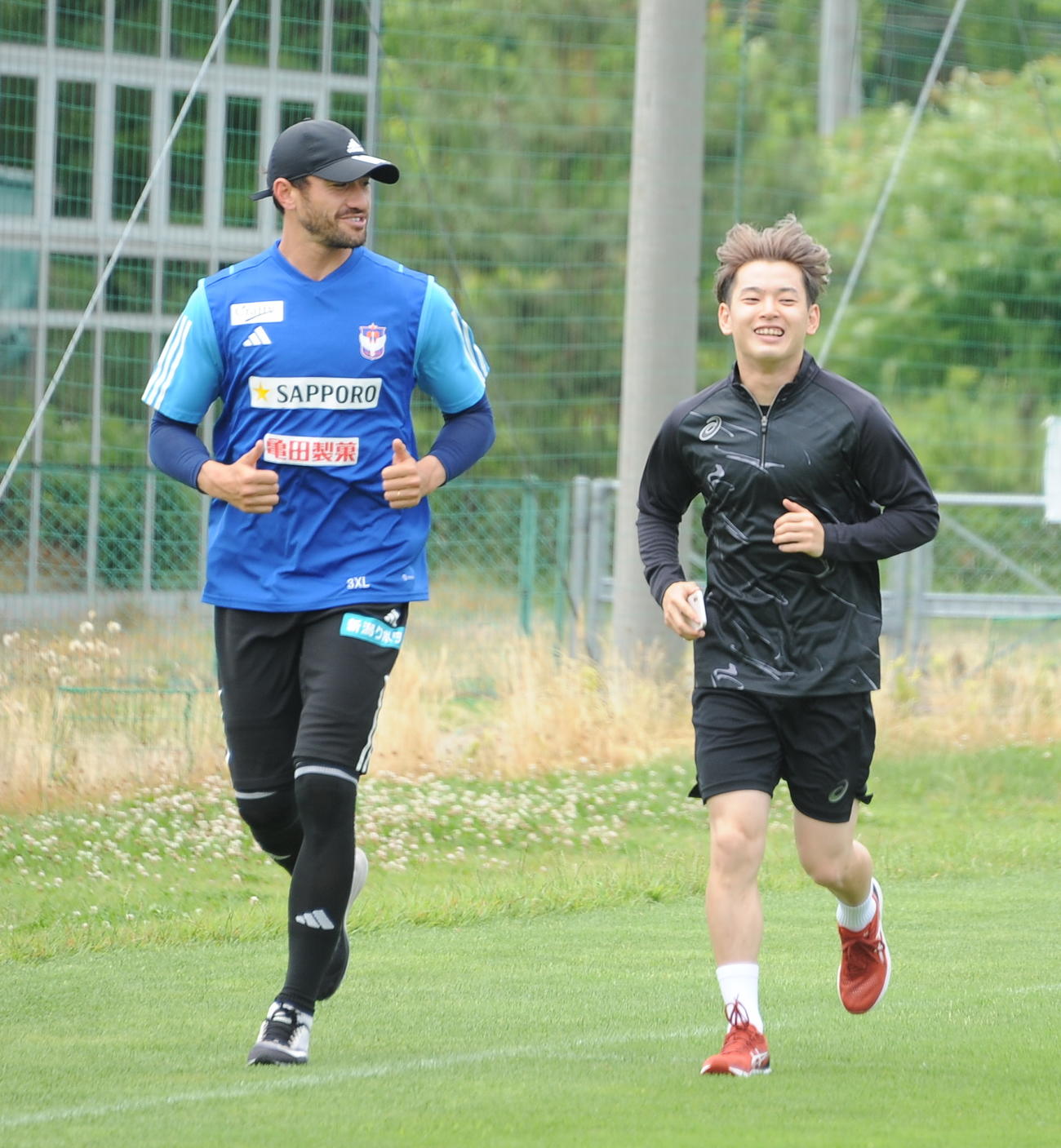 古巣新潟の練習場で舞行龍（左）とランニングする本間