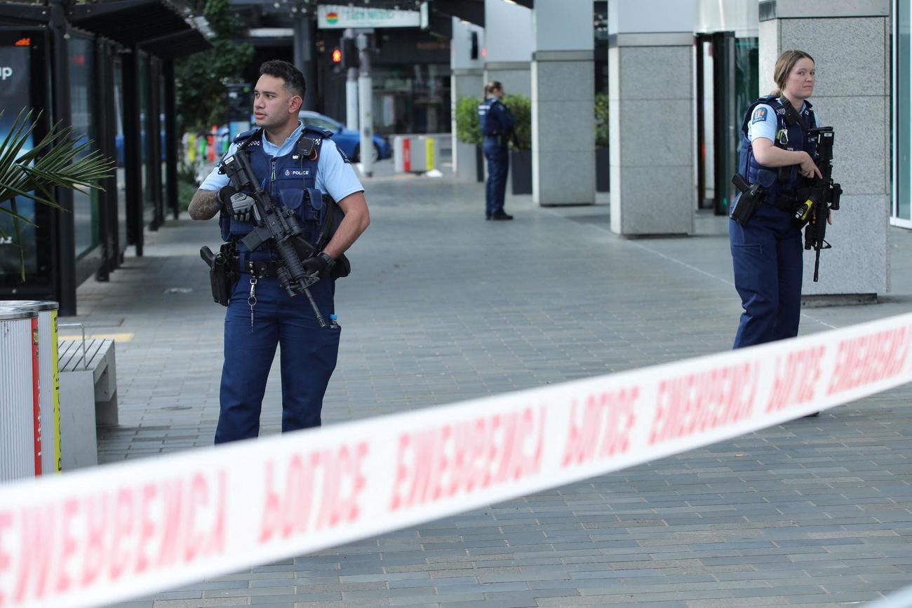 20日、ニュージーランド・オークランドで起きた銃乱射の現場近くで警備に当たる警察官（ロイター＝共同）