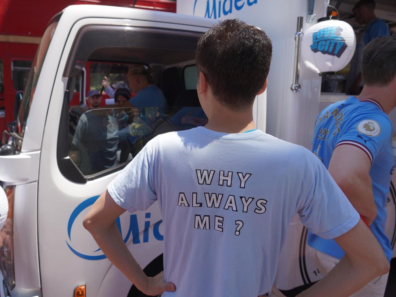 マンチェスター・シティーFWハーランドらが出席したキッチンカーイベントに「WHY ALWAYS ME？」のシャツを着用して参加した男性（撮影・佐藤成）