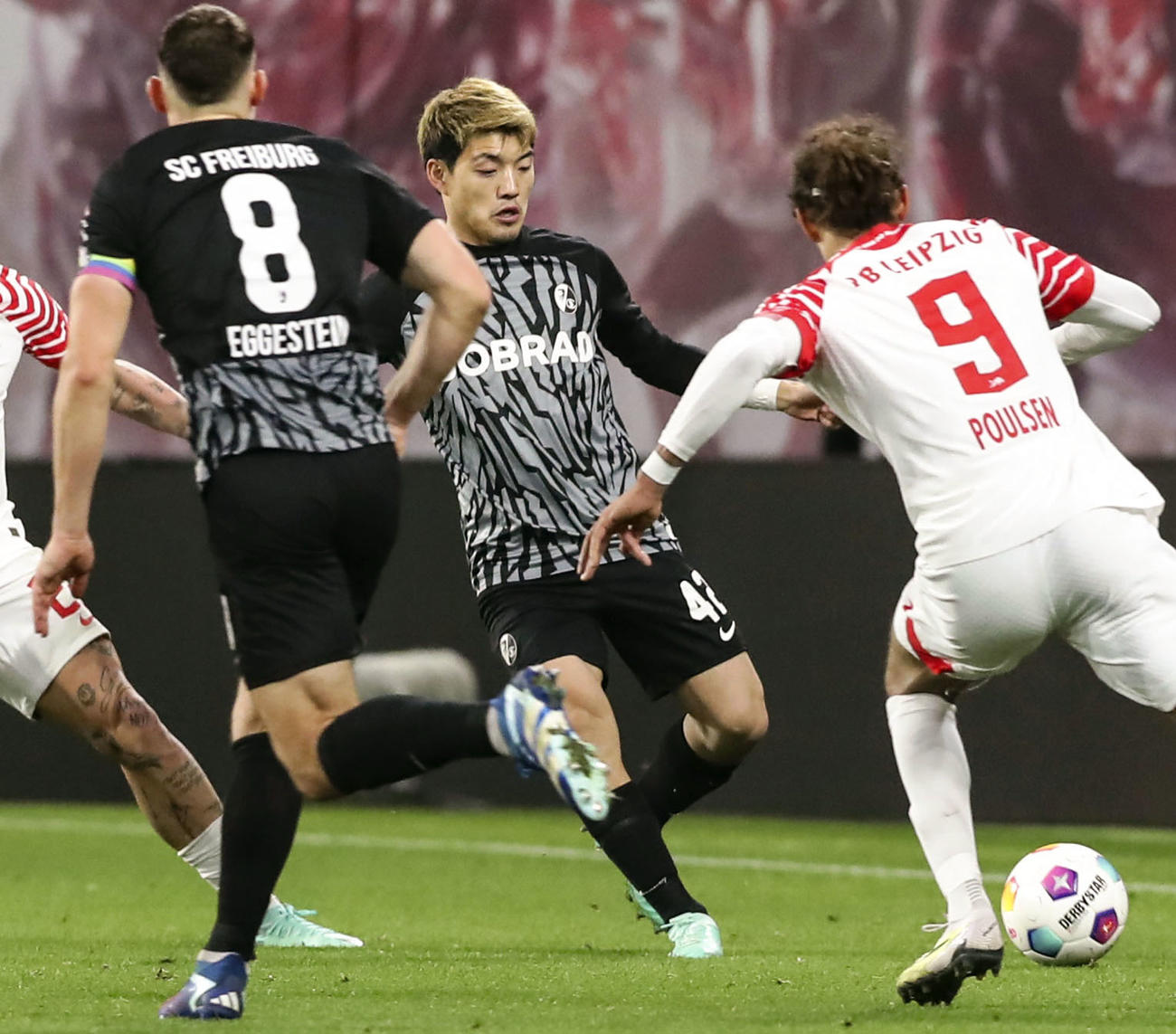 ライプチヒ戦で、競り合うフライブルクの堂安（中央）（共同）