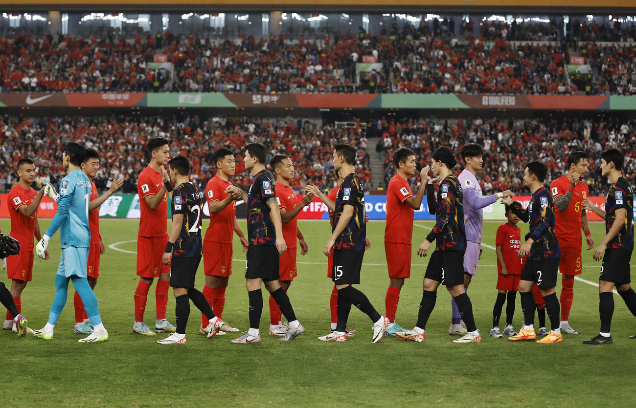 試合前に握手する韓国と中国の両代表（ロイター）