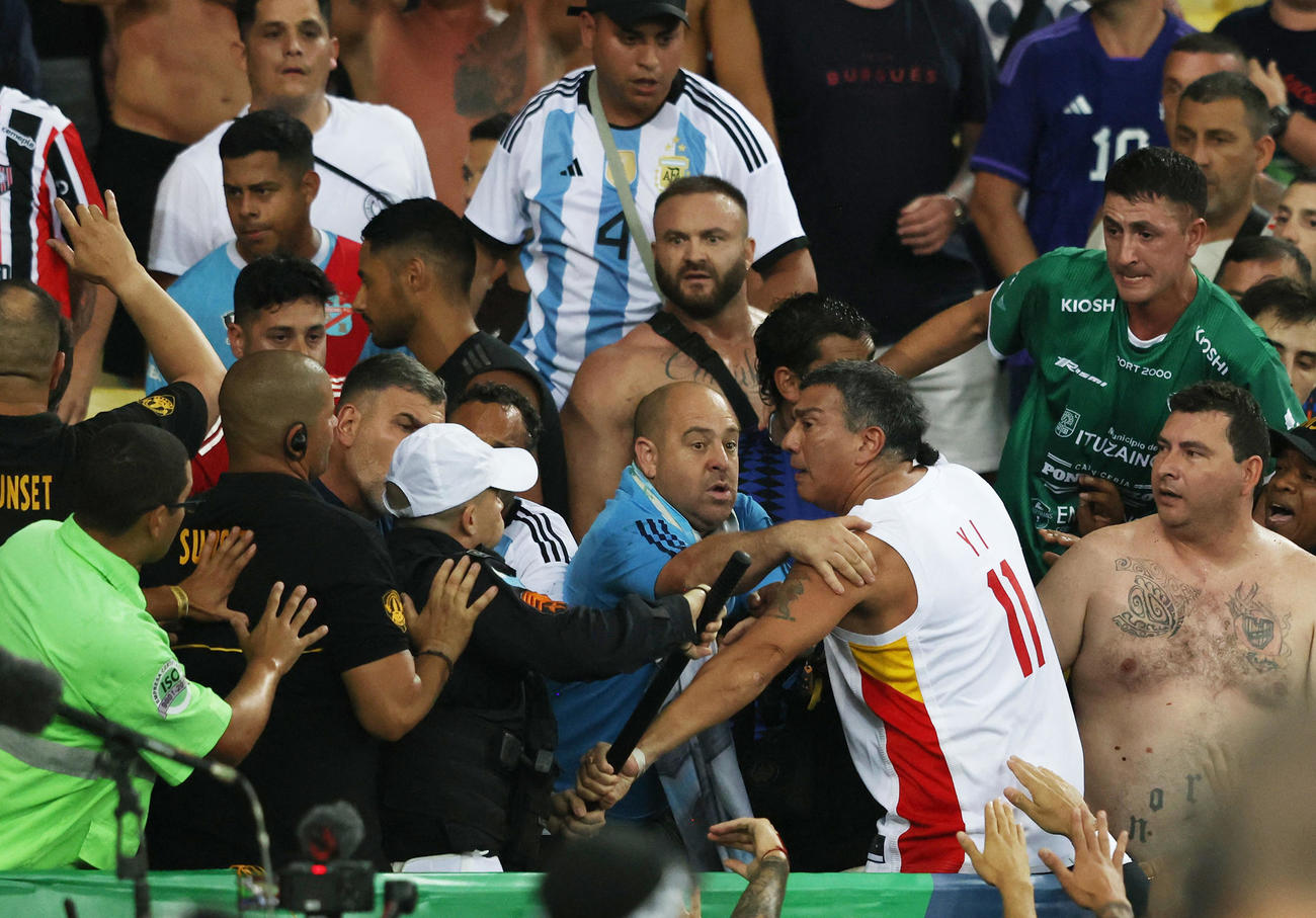 ブラジル対アルゼンチンの試合開始を遅らせようとする警備員とスタンドで衝突するサポーターたち（ロイター）