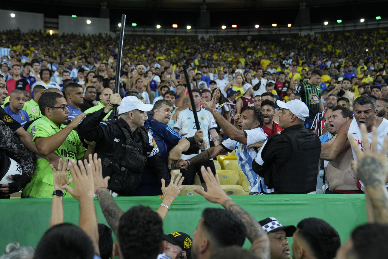 試合前に勃発したブラジルファンとアルゼンチンファンの間の喧嘩を止めようとする警官(AP)