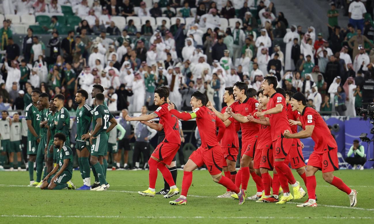 PK戦を制し喜ぶ韓国の選手（手前）とサウジアラビアの選手（奥）（ロイター）