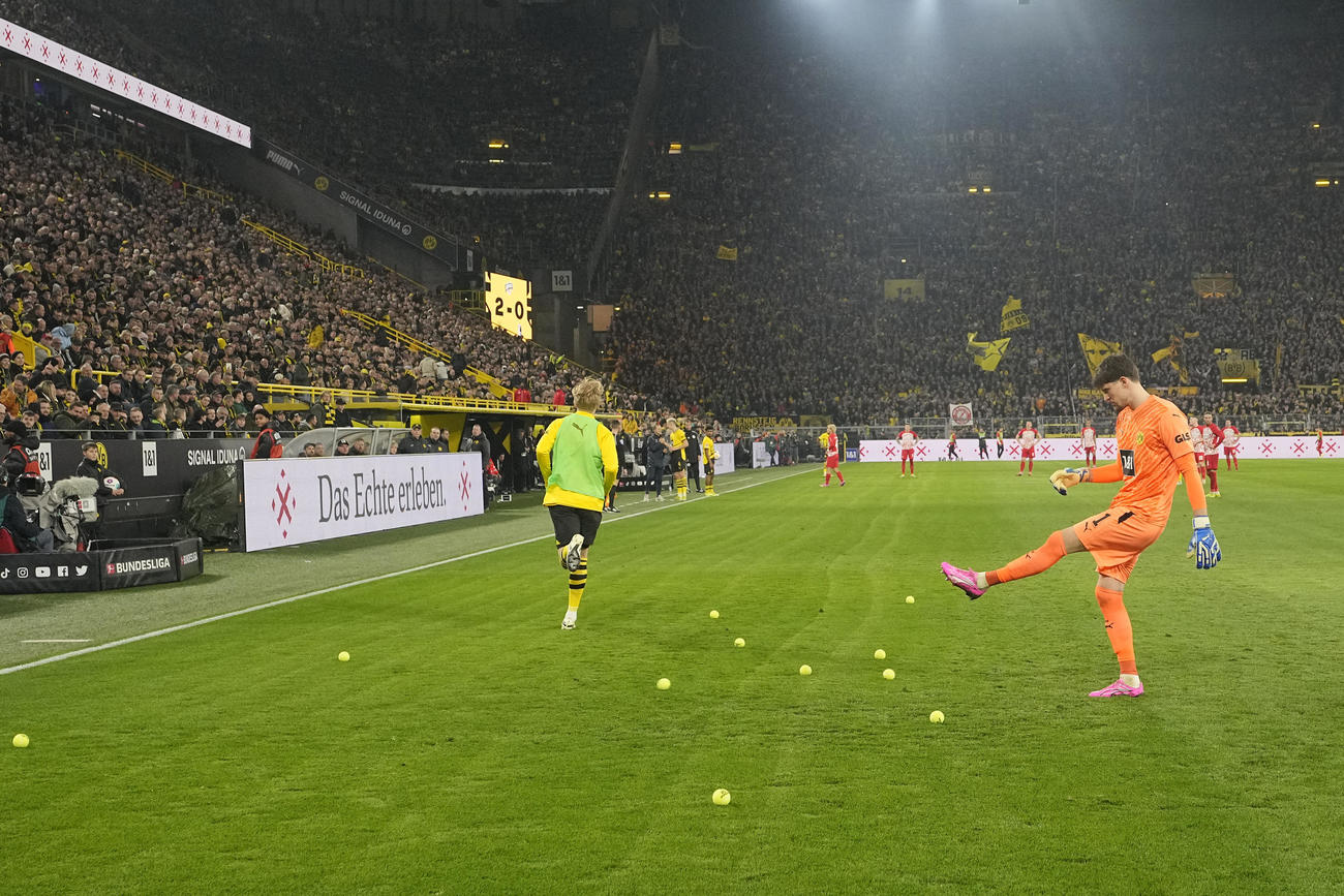 フライブルク戦、ピッチに投げ込まれた大量のテニスボールを蹴り出すドルトムントGKコベル（AP）