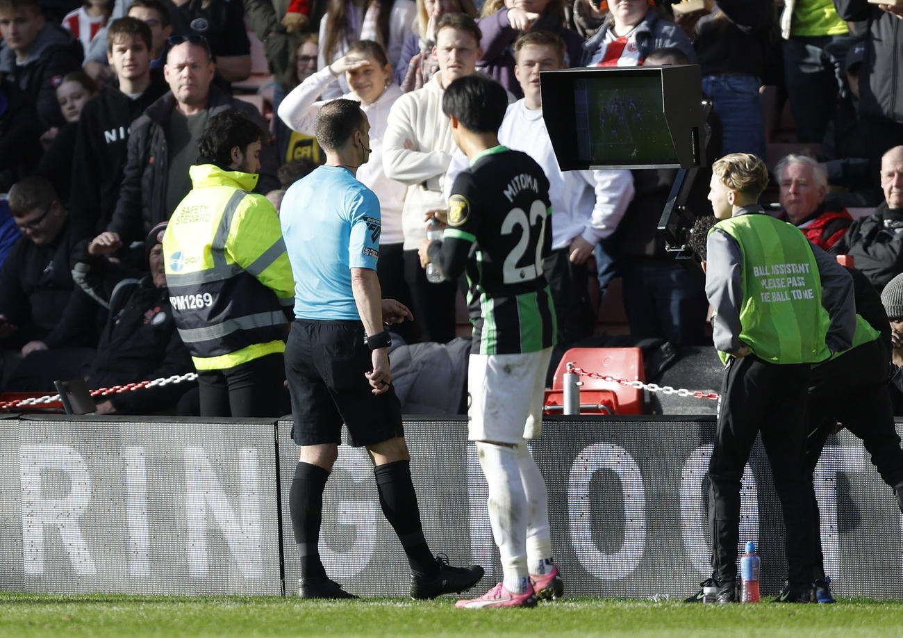 VAR用のモニターをチェックする審判を見つめる三笘（AP)