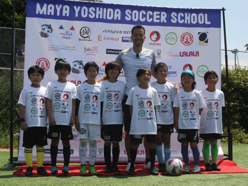 サッカー教室で参加者の子どもたちと記念撮影する吉田麻也