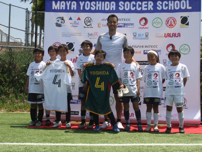 サッカー教室で参加者の子どもたちと記念撮影する吉田麻也