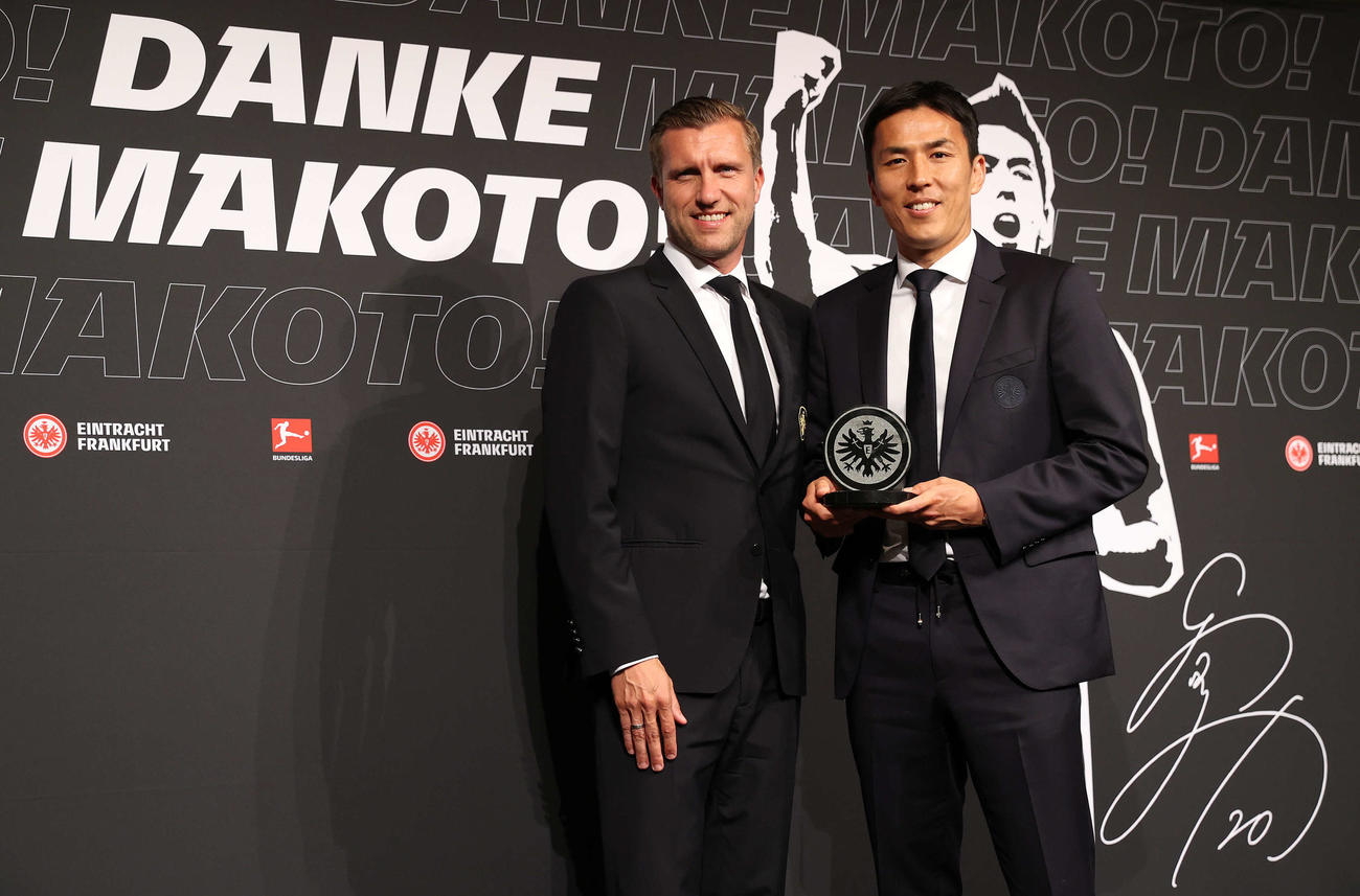 引退会見で記念品を受け取ったサッカー元日本代表の長谷部（右）。左はフランクフルトのクレーシェSD（撮影・河野匠）