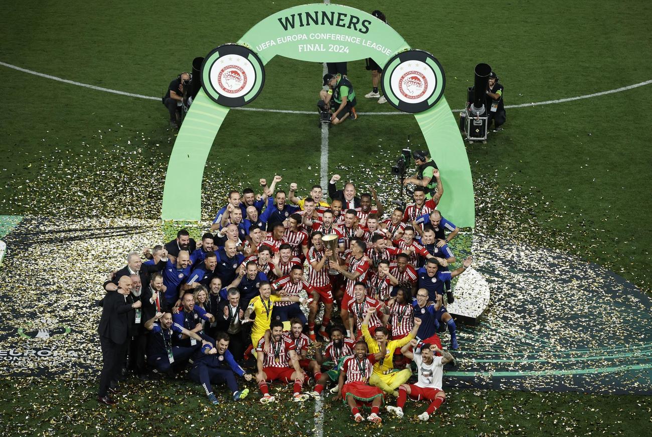 トロフィーを掲げてチームメイトと祝うオリンピアコスの選手ら（ロイター）