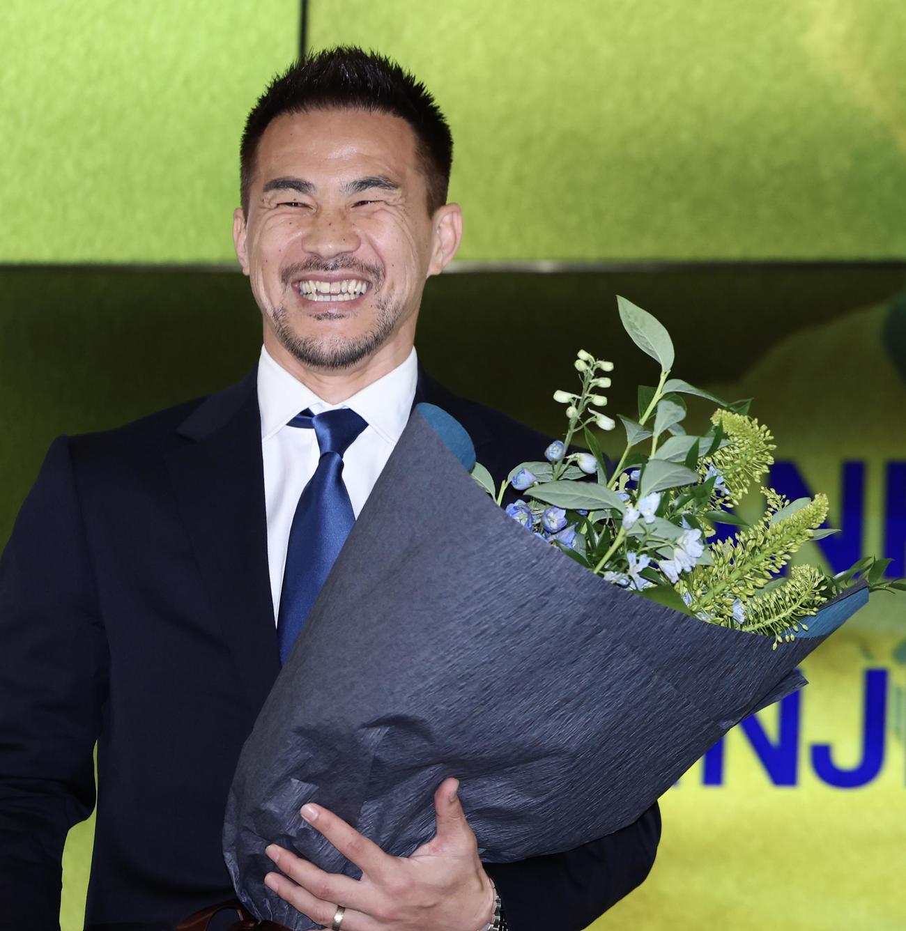 引退会見で花束を手に笑顔を見せる岡崎（撮影・河田真司）