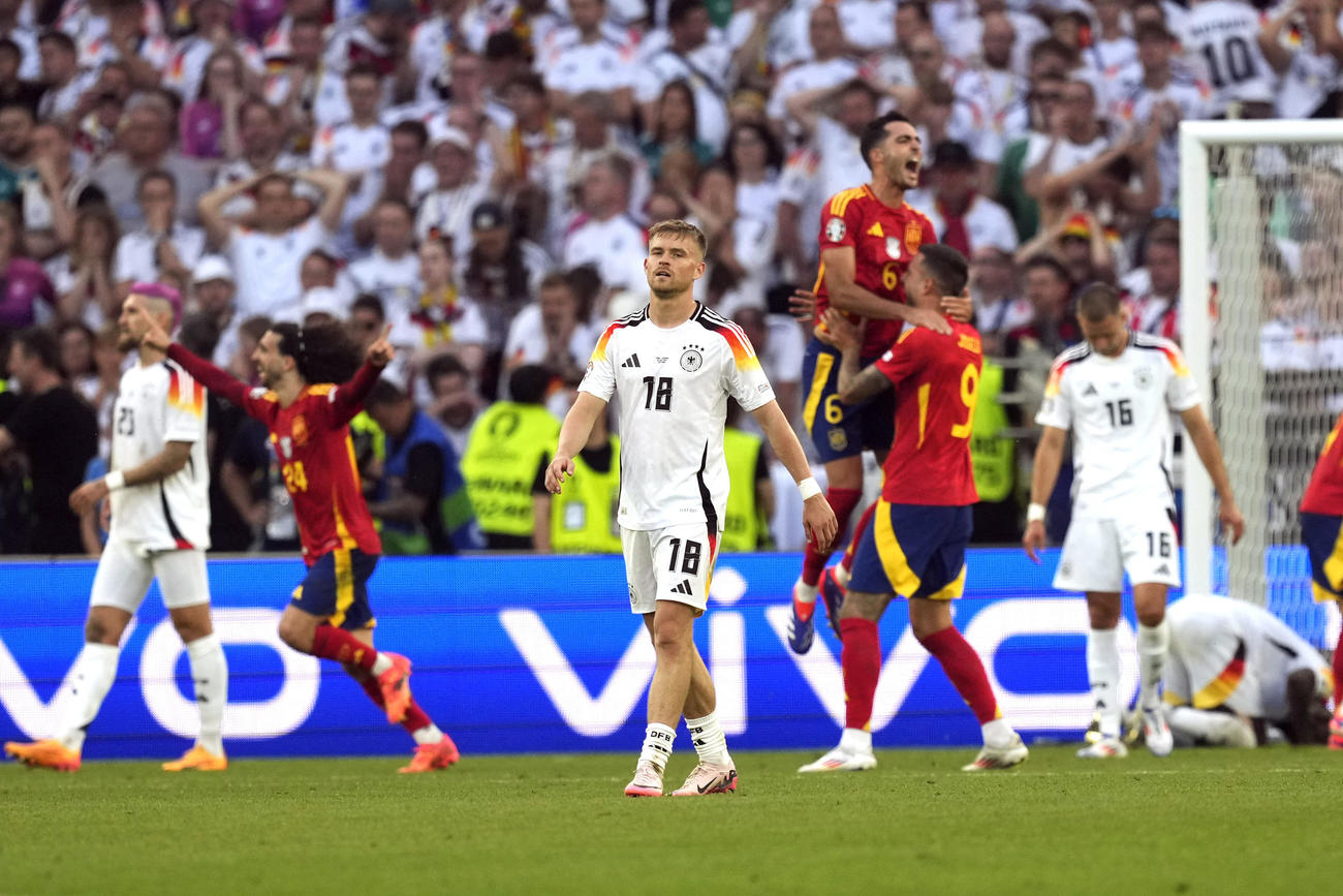 土壇場で決勝点が飛び出し、喜ぶスペインとうなだれるドイツ（AP)