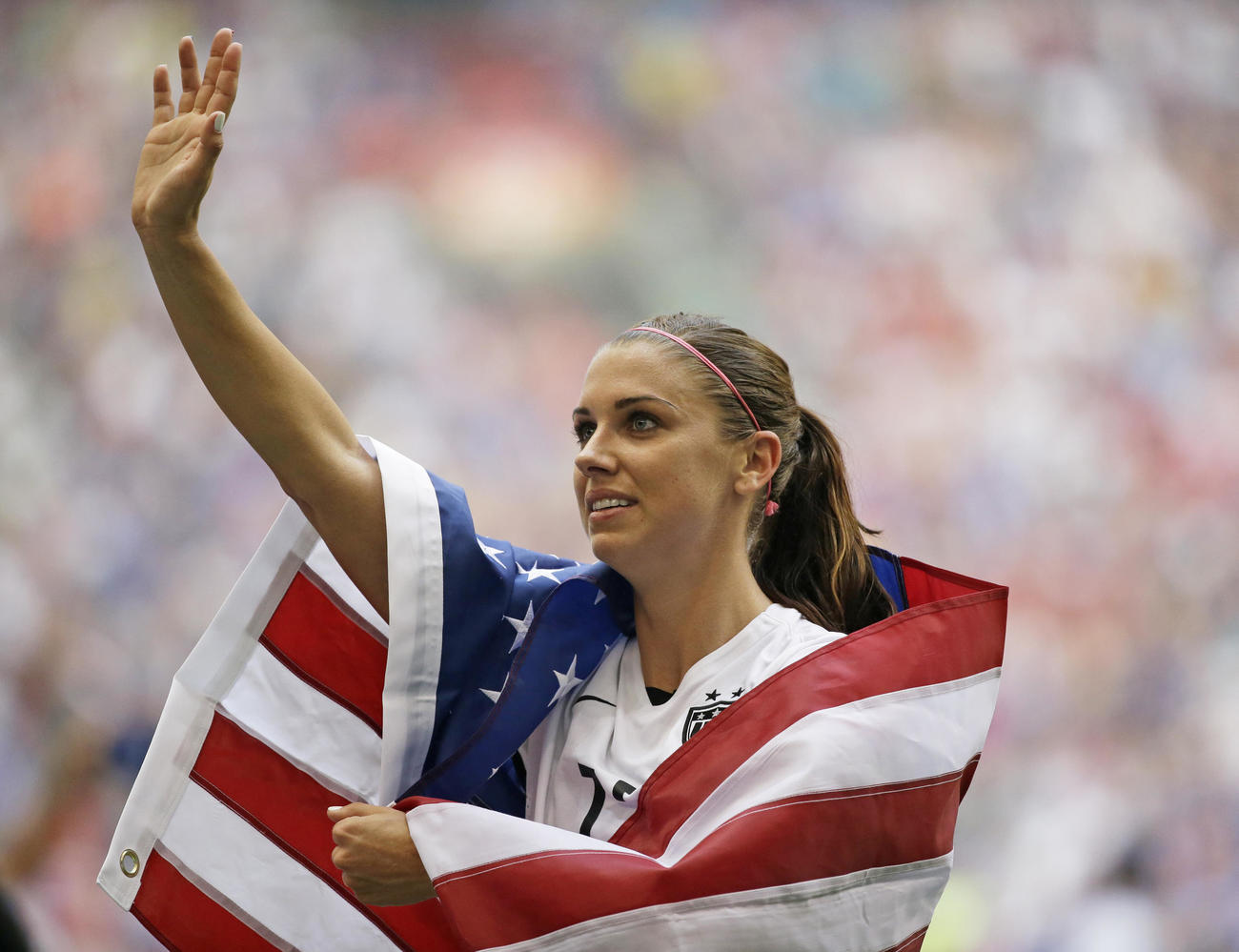 2015年7月5日　女子ワールドカップで日本を倒したあと国旗をまとう米国のアレックス・モーガン（AP）
