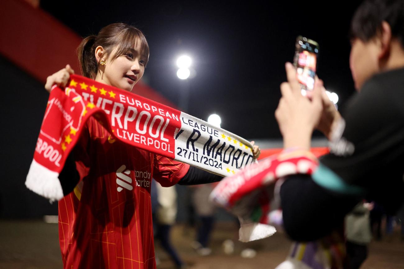 試合前にスタジアムの外でポーズをとるリバプールサポーター（ロイター）