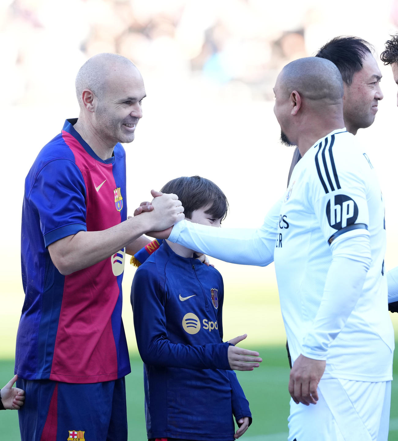 バルセロナ・レジェンズ対Rマドリード・レジェンズ　試合前、握手を交わすイニエスタ（左）とロベルト・カルロス（撮影・横山健太）