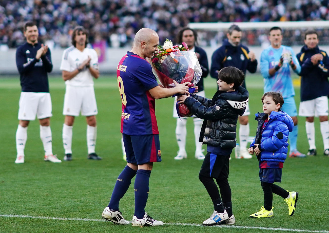 バルセロナ・レジェンズ対Rマドリード・レジェンズ　試合を終え、子供たちから花束を受け取るイニエスタ（左）（撮影・横山健太）
