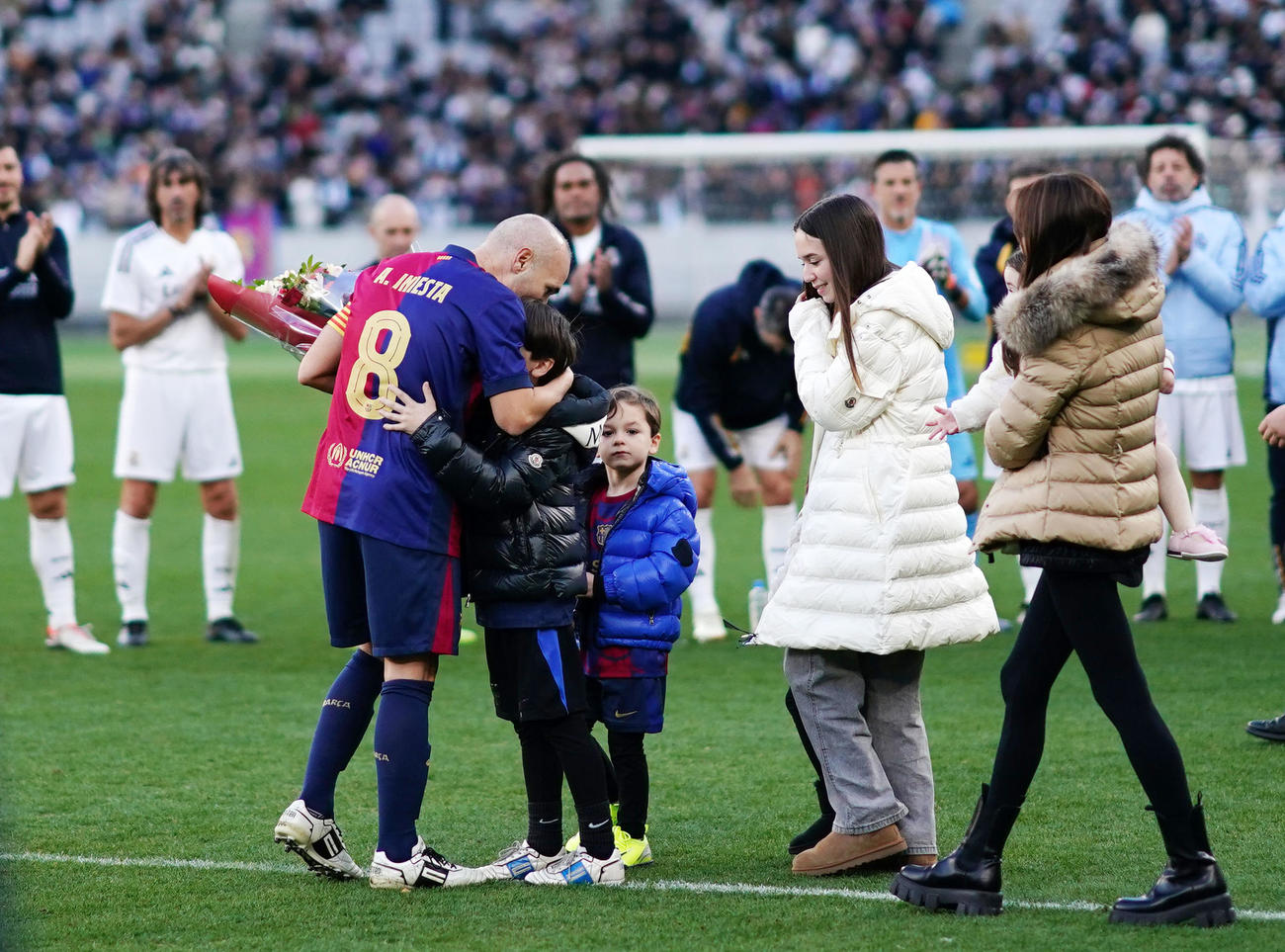 バルセロナ・レジェンズ対Rマドリード・レジェンズ　試合を終え、子供たちから花束を受け取るイニエスタ（左）（撮影・横山健太）