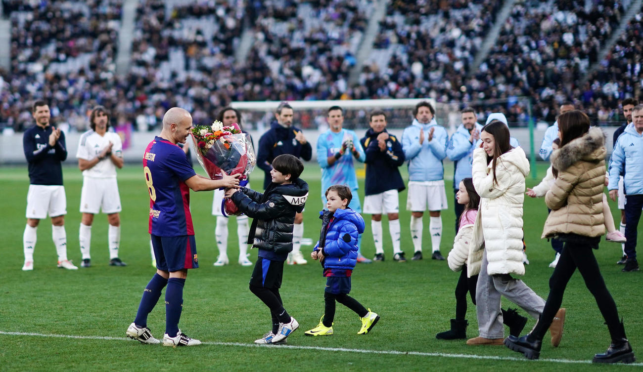 バルセロナ・レジェンズ対Rマドリード・レジェンズ　試合を終え、子供たちから花束を受け取るイニエスタ（左）（撮影・横山健太）
