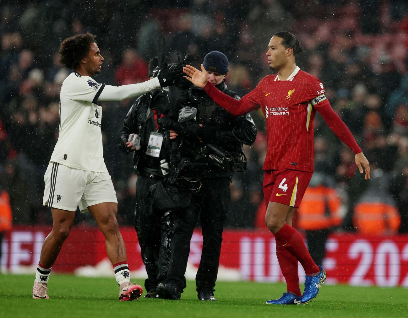 ドローに終わった試合後、握手するリバプールのファンダイク（右）とマンチェスター・ユナイテッドのジョシュア・ザークツィー（２０２５年１月５日、ロイター）