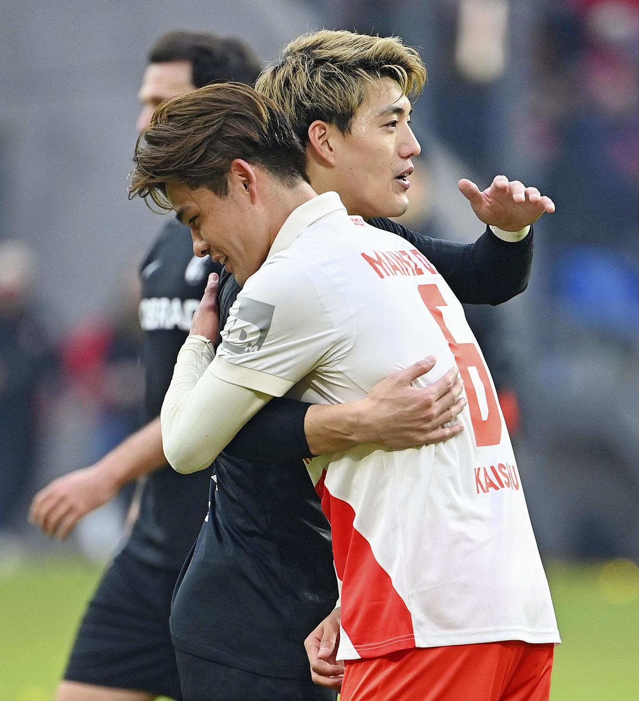 試合後、健闘をたたえ合うマインツの佐野（手前）とフライブルクの堂安（共同）