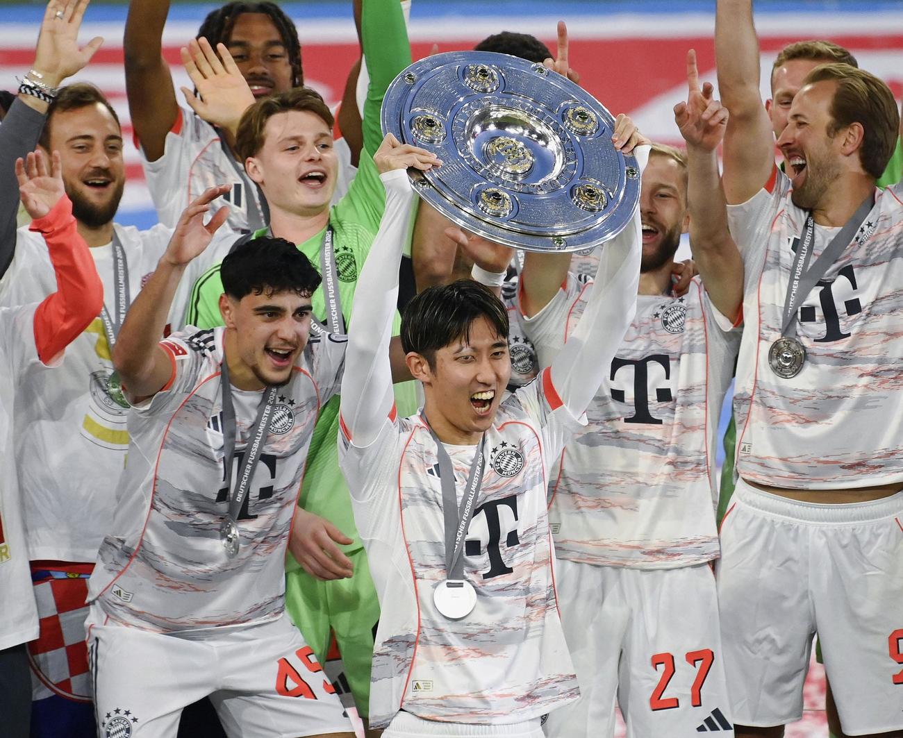 優勝セレモニーで、マイスターシャーレを掲げ喜ぶバイエルン・ミュンヘン伊藤（中央）（共同）