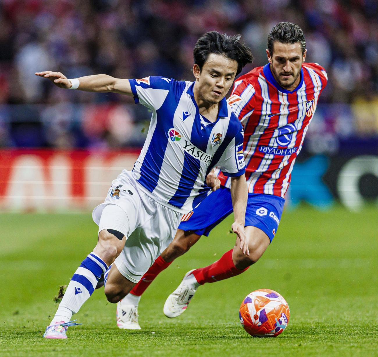 アトレチコ・マドリード戦の前半、競り合うレアル・ソシエダードの久保（左）（共同）