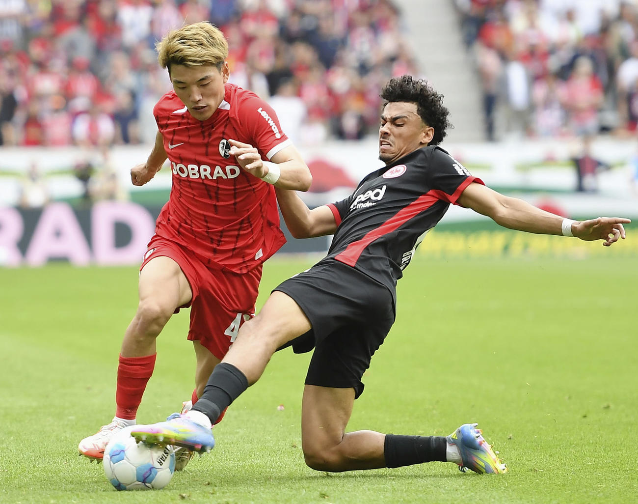 Eフランクフルト戦で競り合うフライブルクの堂安（左）（共同）