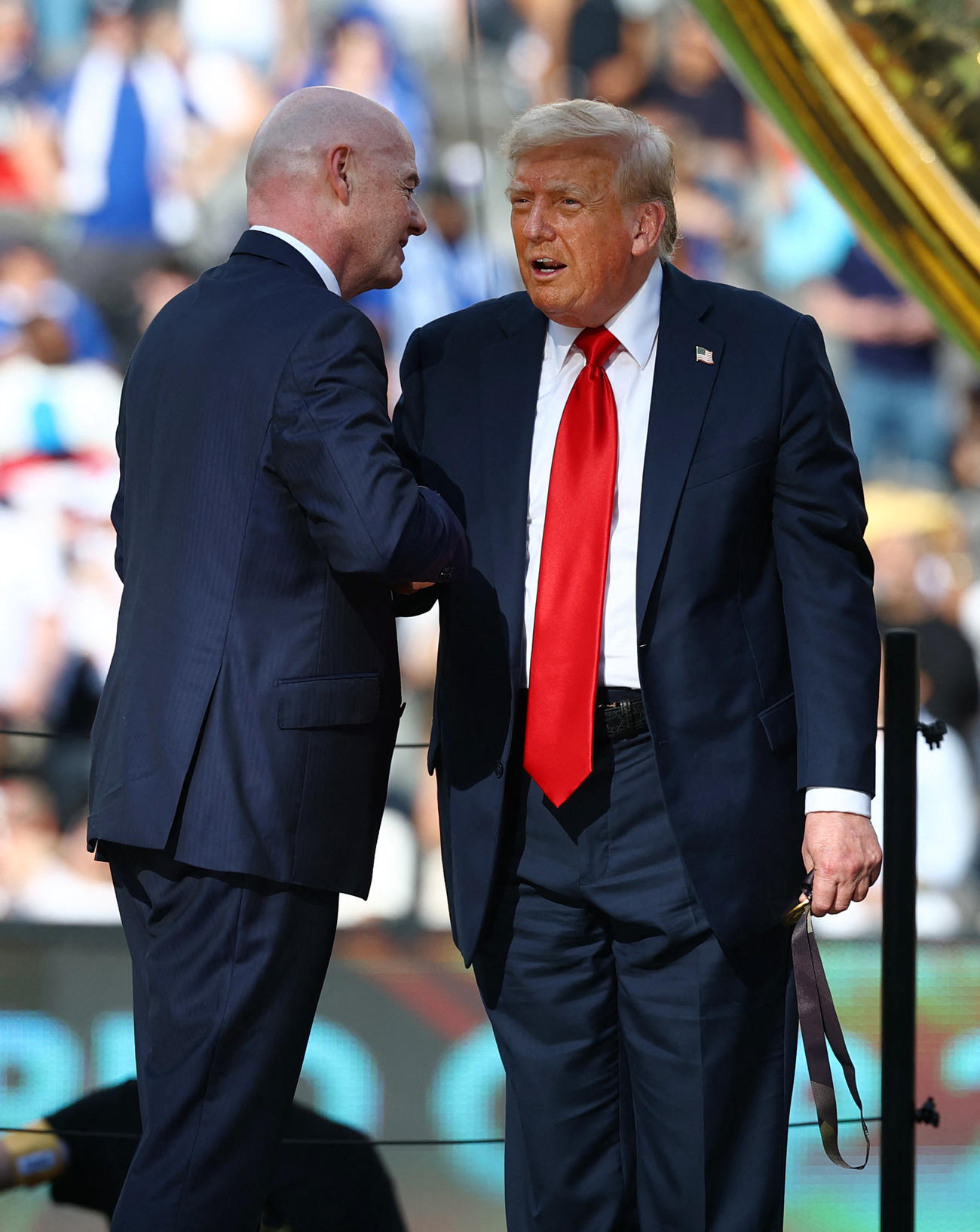 トロフィー授与の際、FIFAのインファンティノ会長と握手するドナルド・トランプ米大統領（右、ロイター）