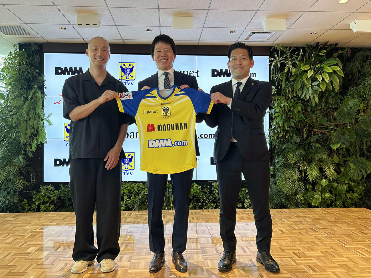 資本業務提携を締結したジャパネットホールディングスの高田旭人社長（中央）。左はDMM.comの村中悠介COO、右は同社の緒方悠執行役員