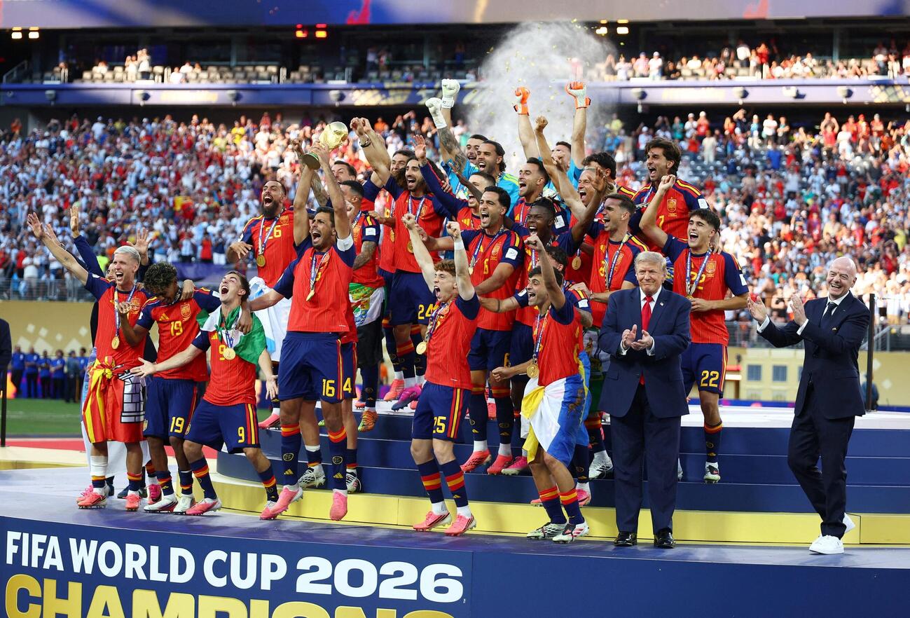 2026年7月19日、ワールドカップ優勝を果たしトロフィーを掲げて喜ぶスペインの選手たちと、その様子を見守るトランプ大統領とFIFAのインファンティノ会長（ロイター）