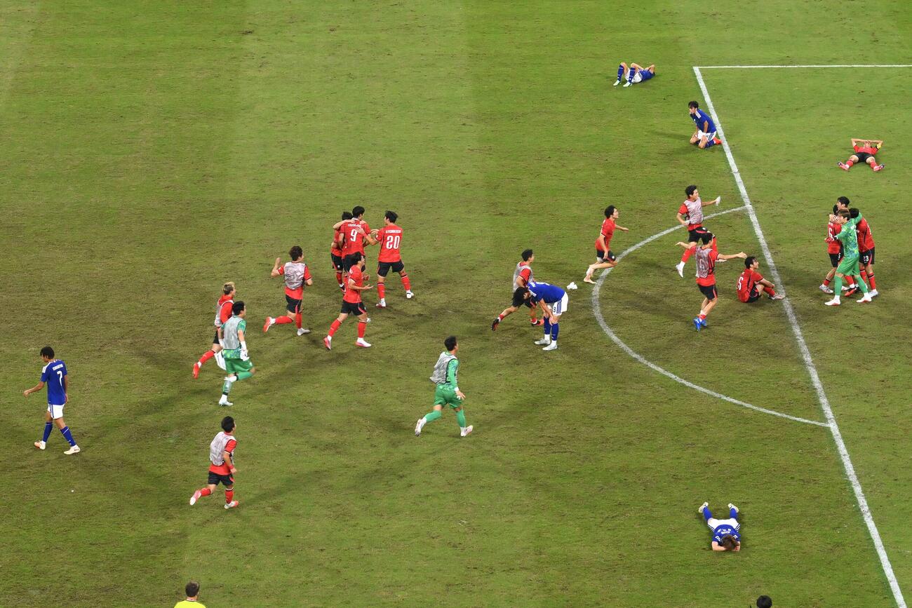 日本対韓国　優勝を逃しうなだれる日本の選手とピッチへ駆けつける韓国の選手たち（撮影・滝沢徹郎）