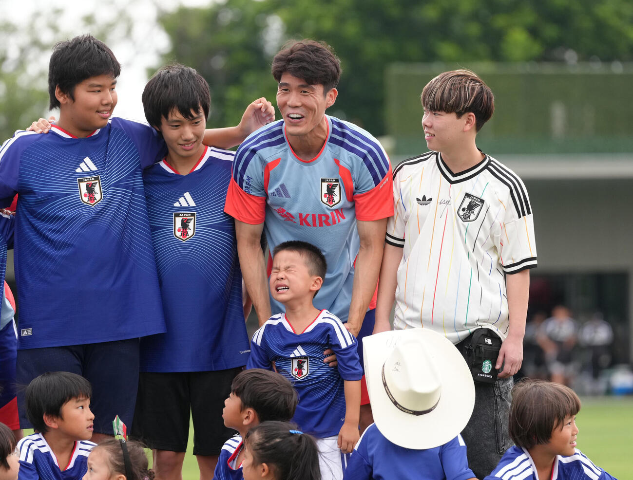 サッカー日本代表W杯北中米大会事前合宿　練習前、記念撮影の際、泣き出してしまった子どもに戸惑いの表情を見せる冨安健洋（撮影・足立雅史）