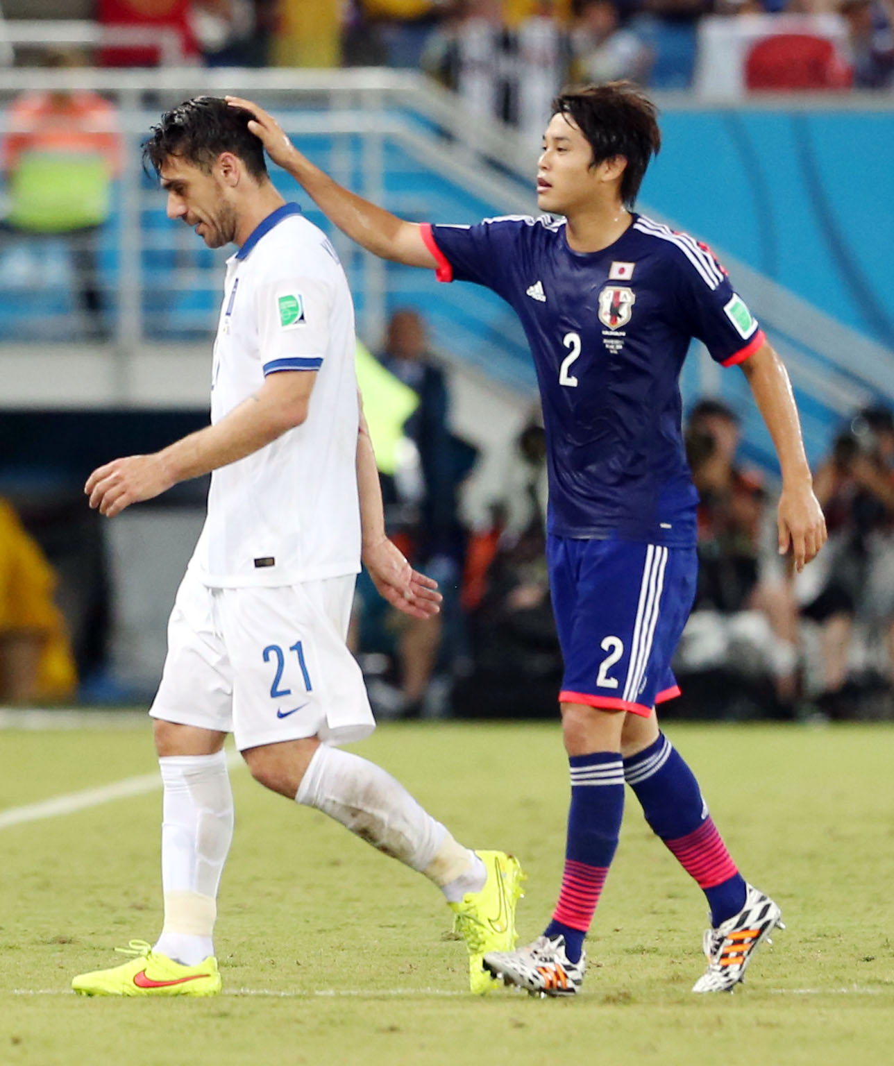 W杯ブラジル大会　レッドカードで退場するギリシャ代表カツラニスの頭をなでる日本代表内田篤人（2014年6月撮影）