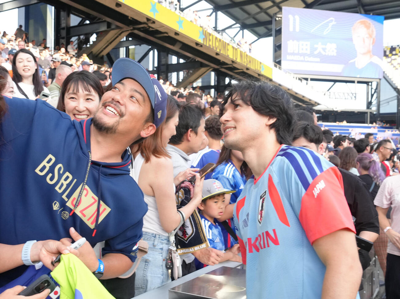 サッカー日本代表W杯北中米大会ベースキャンプ　スタンドのファンの写真撮影に応える南野拓実（撮影・足立雅史）