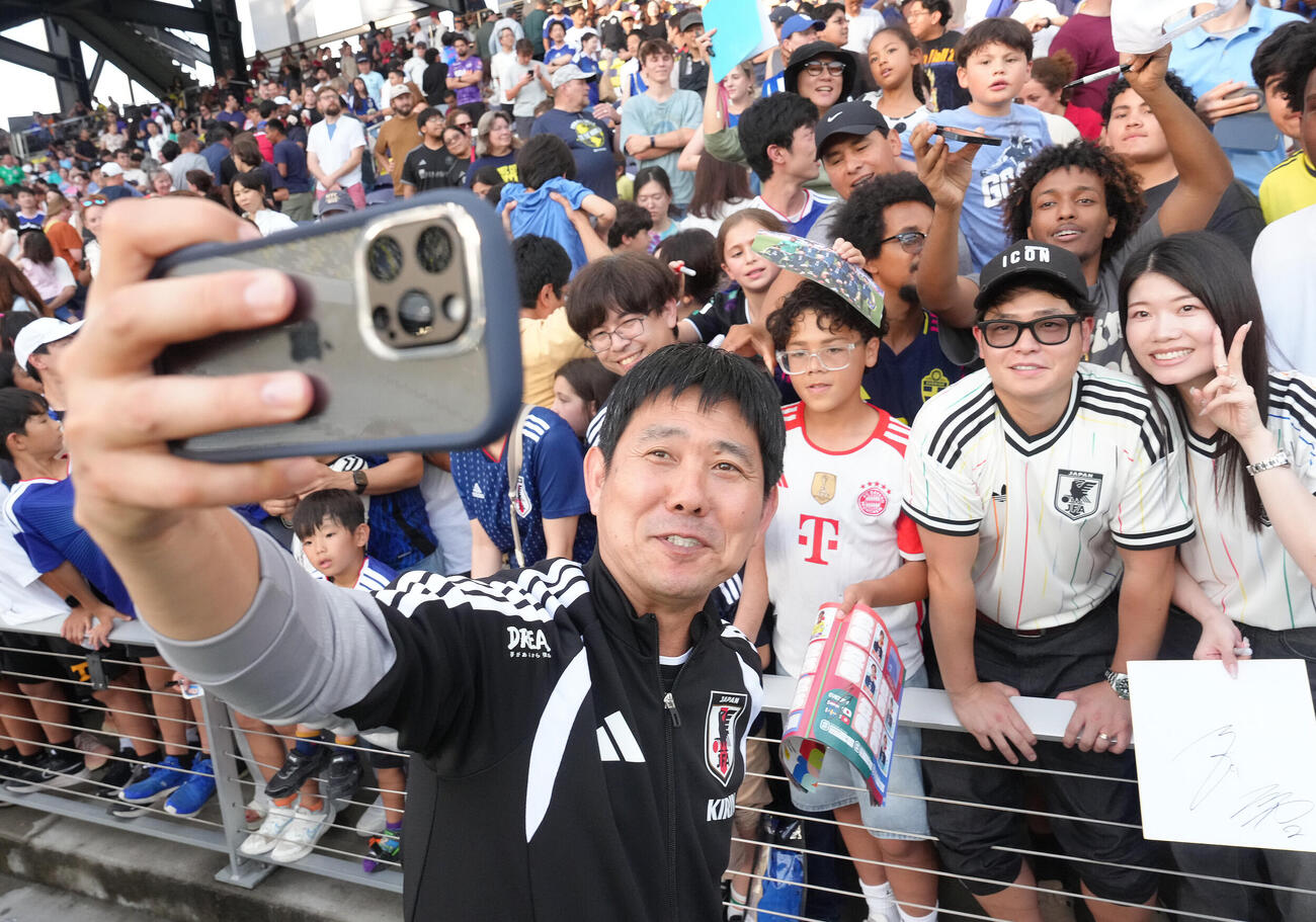 サッカー日本代表W杯北中米大会ベースキャンプ　スタンドのサポーターらとの記念撮影に笑顔を見せる森保一監督（撮影・足立雅史）＝2026年6月8日（現地時間）
