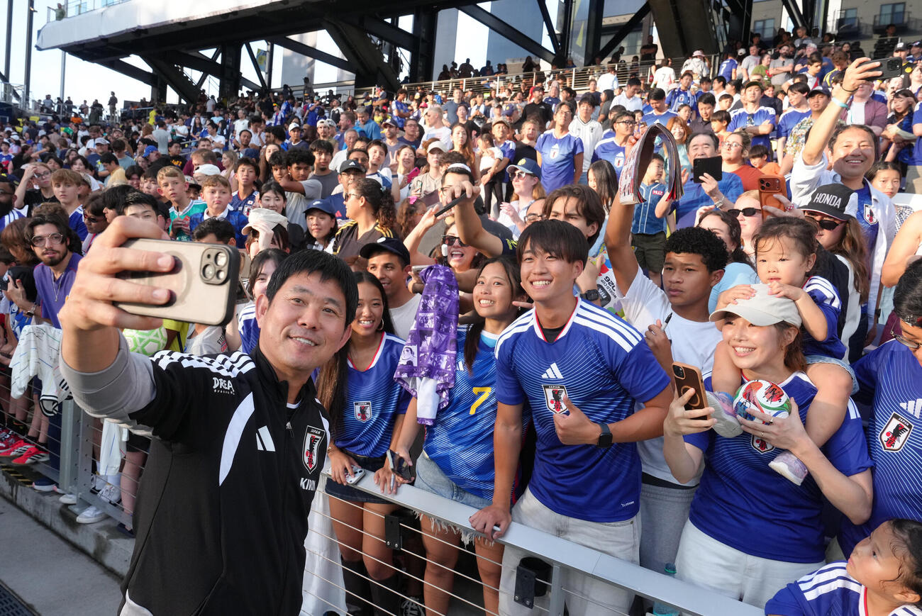 サッカー日本代表W杯北中米大会ベースキャンプ　スタンドのサポーターらとの記念撮影に笑顔を見せる森保一監督（撮影・足立雅史）＝2026年6月8日（現地時間）