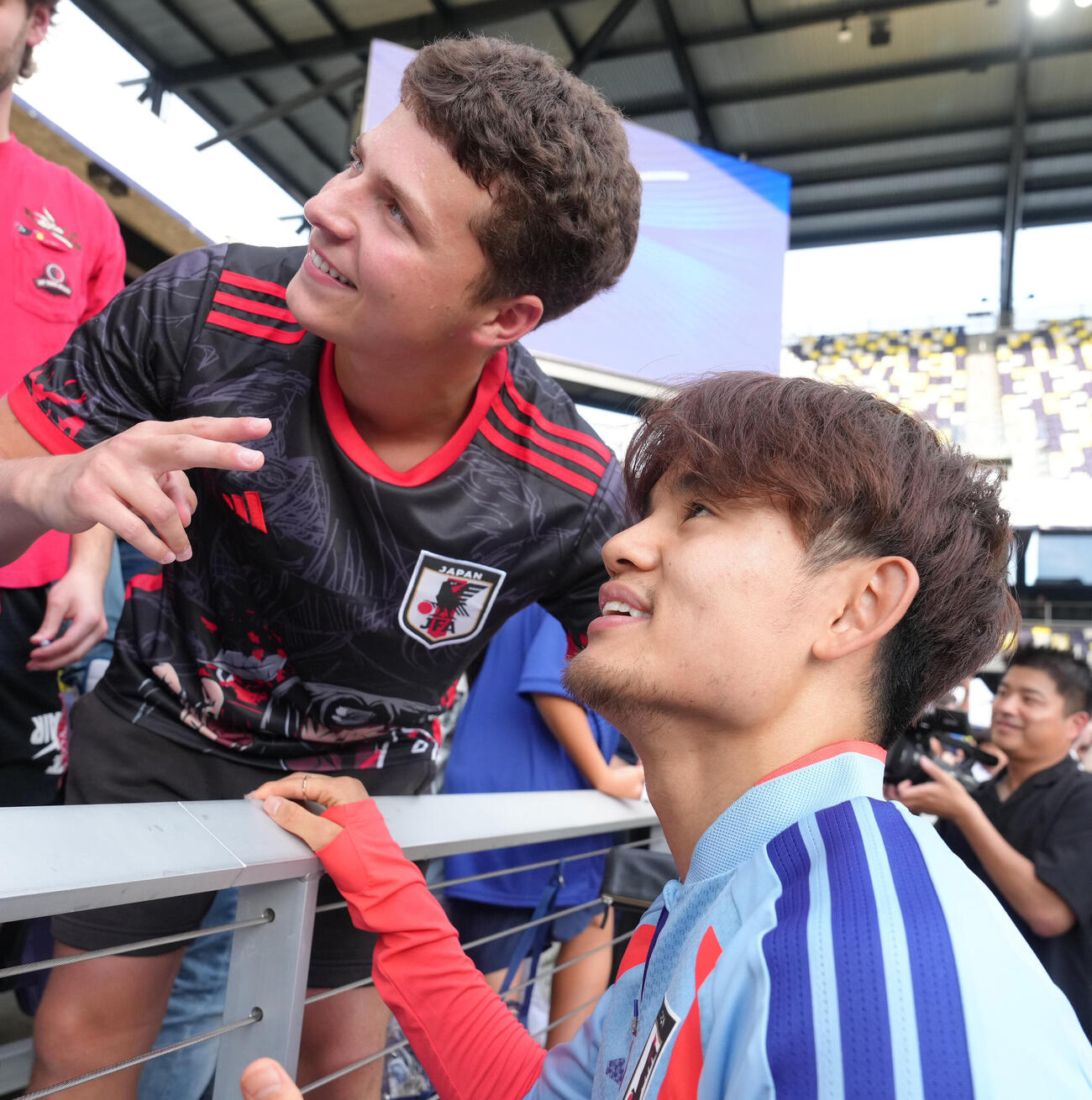 サッカー日本代表W杯北中米大会ベースキャンプ　海外サポーターとの記念撮影に笑顔を見せる久保建英（撮影・足立雅史）＝2026年6月8日（現地時間）