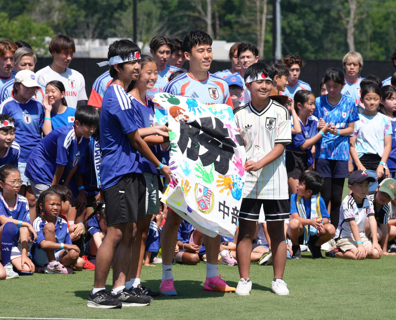 サッカー日本代表W杯北中米大会ベースキャンプ　現地の子どもたちから応援メッセージの入った横断幕を受け取る遠藤航（右）（撮影・足立雅史）