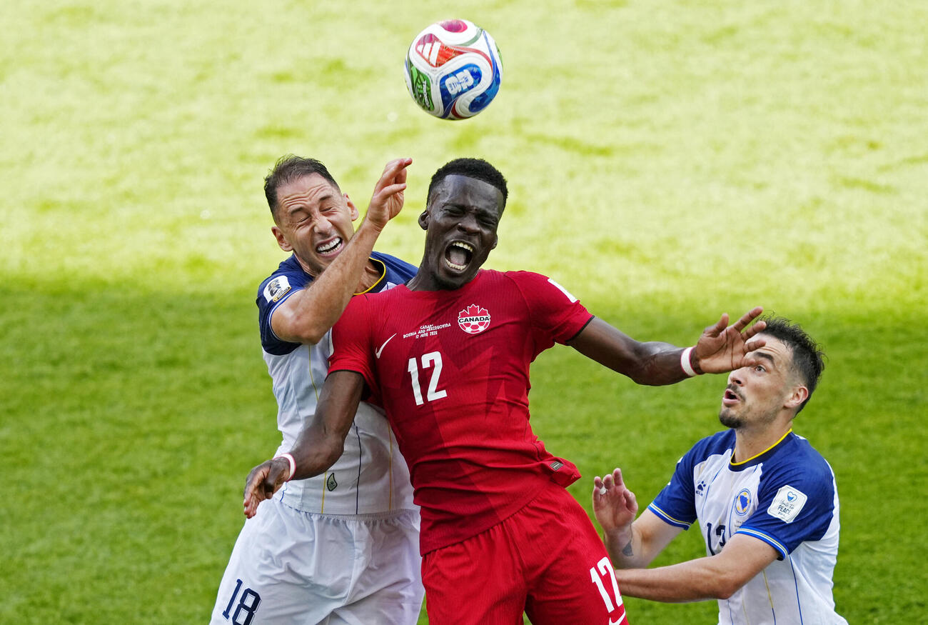 Soccer Football－FIFA World Cup 2026－Group B－Canada v Bosnia and Herzegovina－Toronto Stadium, Toronto, Canada－June 12, 2026 Canada's Tani Oluwaseyi in action with Bosnia and Herzegovina's Nikola Katic and Ivan Basic IMAGN IMAGES via Reuters／Kevin Sousa