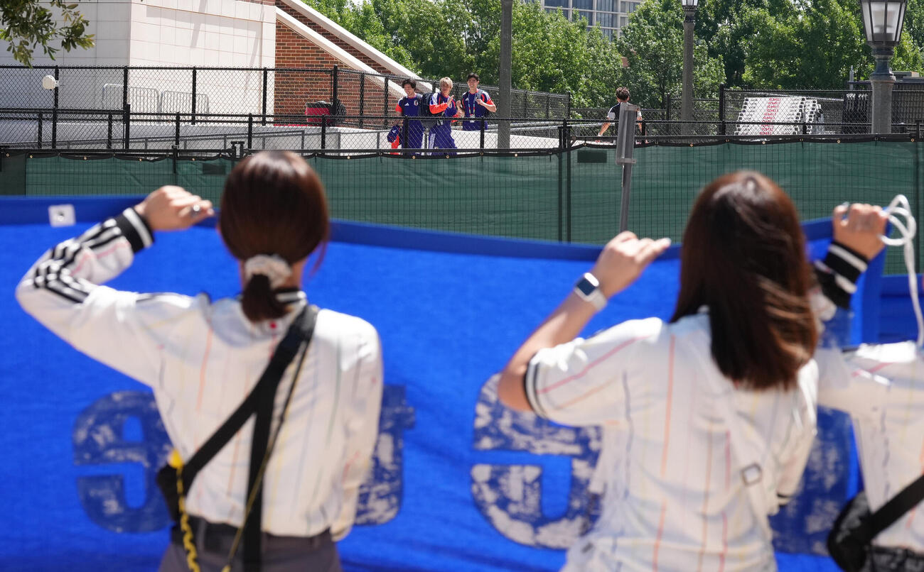 練習場の外からのサポーターの声援に笑顔で応える、左から南野拓実、伊東純也、谷口彰悟（撮影・足立雅史）