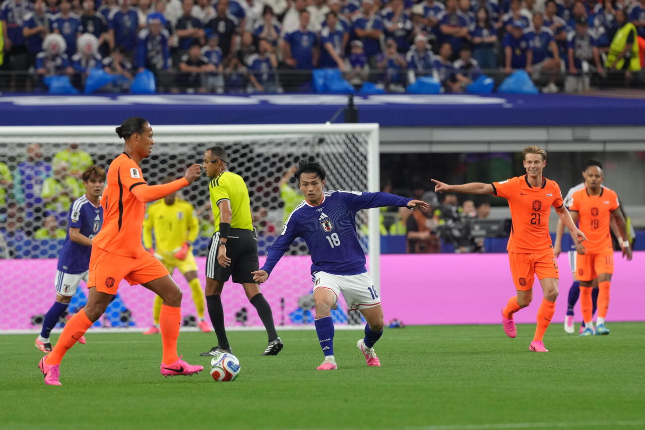 W杯北中米大会　1次リーグ　第1戦　日本対オランダ　前半、ドリブルするオランダのファージル・ファンダイク（左）のボールをカットに向かう上田綺世。手前右はフレンキー・デヨング（撮影・足立雅史）