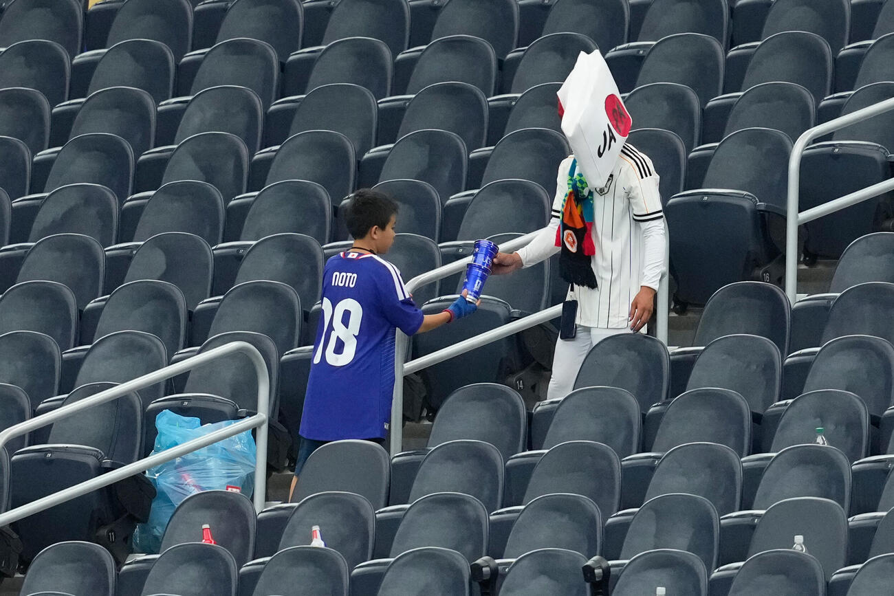 オランダ戦後、スタジアムを清掃する日本のサポーター（AP）