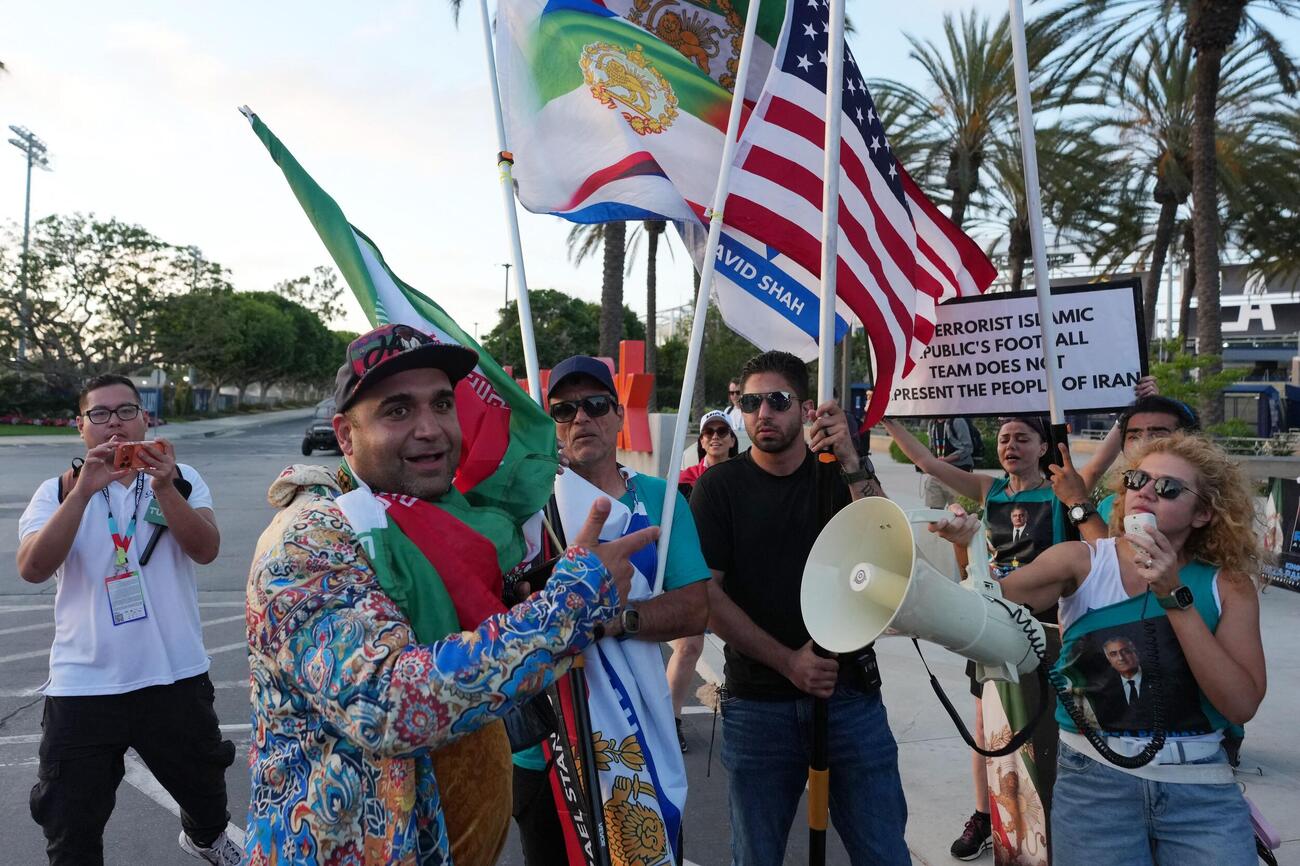 イラン代表の練習スタジアム外で、反体制派の抗議者たちと向かい合うイラン政権支持の抗議者（ロイター）