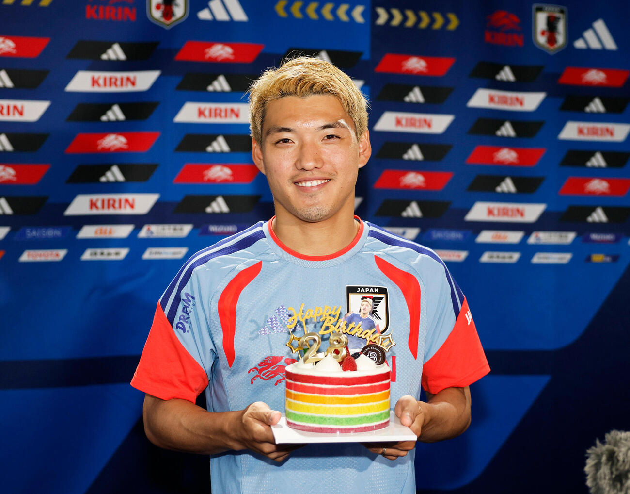 誕生日迎えバースデーケーキを手に笑顔を見せる堂安律